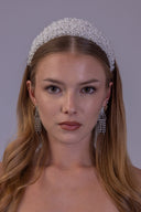 White pearl wedding crown shown at an angle, with densely layered clear beads creating an elegant bridal headpiece