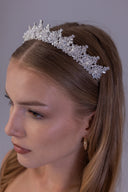 Close angled view showing the wedding tiara’s dimensional zircon foliage, luminous pearl centres and frost-inspired silver detailing.