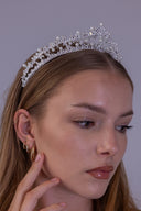 Angled bridal portrait featuring a princess-style zircon tiara with luminous pearls and a delicate openwork crown silhouette.