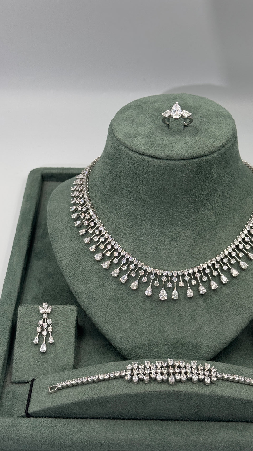 Close view of clear zircon statement necklace with round tennis stones and graduated pear cut fringe