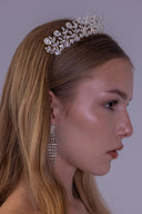 Close side view of a botanical zircon bridal crown showing its open vine structure and teardrop stone accents.