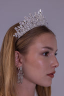 Front close-up of a royal zircon bridal crown with a tall center peak, teardrop stones and dense silver botanical detailing