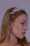 Front close-up of a silver flower bridal crown with symmetrical zircon leaves, designed as an elegant tiara for weddings