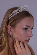 Side profile of an elegant silver bridal crown embellished with clear zircon leaf clusters and evenly spaced white pearls.