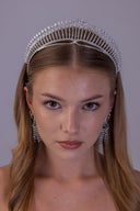 Angled view of a bride wearing a royal silver bridal tiara with an elevated sunburst silhouette and clear zircon detailing