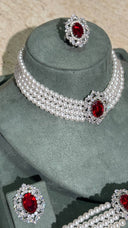 Close-up bridal pearl choker with red gemstone and zircon frame