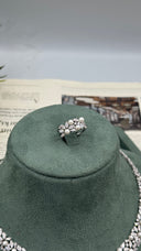 Close-up of an adjustable wedding ring featuring white pearls surrounded by marquise and round zircon stones