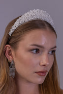 Side view of a white pearl bridal crown showing its raised beaded texture and elegant silver-tone wedding tiara base