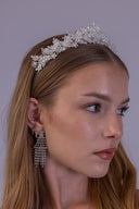 Side profile of a romantic pearl wedding crown showing its floral bead clusters and elegant silver-tone bridal tiara base.