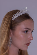Close angled view of a royal silver bridal tiara showing its raised center and symmetrical leaf-inspired zircon pattern.